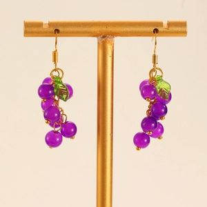 Detail of grape drop earrings with purple resin beads and green leaf on golden metal stand