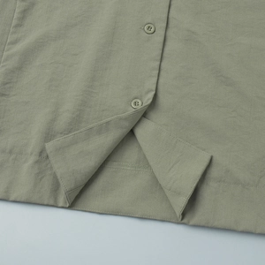Macro shot of single-breasted button placket and textured cotton-linen fabric detail