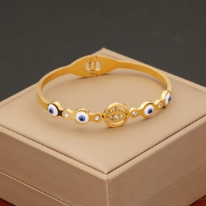 Gold stainless steel snake bangle with evil eye patterns and shimmering white crystals