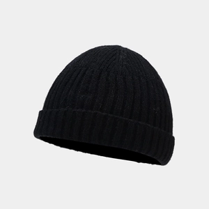 Close-up of black ribbed knit beanie showing the detailed vertical texture and folded cuff