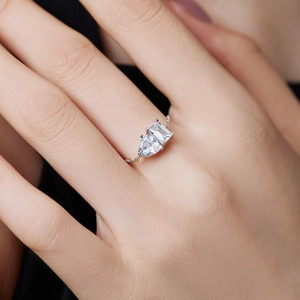 Detail of adjustable silver chain ring featuring emerald and heart-cut cubic zirconia