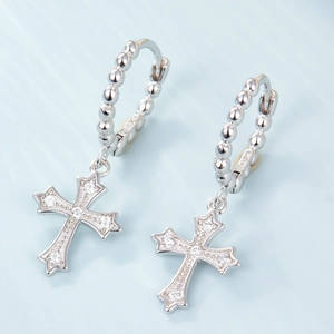 Detailed close-up of S925 silver cross huggie earrings with sparkling cubic zirconia pavé