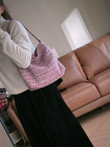 Détail du sac à bandoulière en tweed rose montrant la texture et la forme hobo souple