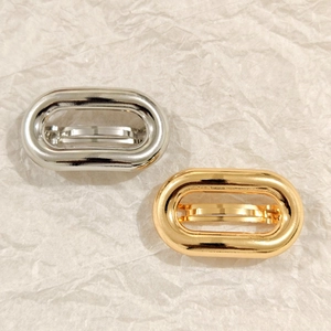 Detailed view of oval gold and silver minimalist alloy hair clips with smooth finish