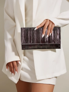 Close-up of metallic pleated evening clutch bag with rectangular flap held by a model