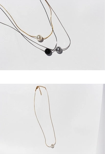 Detailed view of minimalist single pearl pendant necklaces in black white and gray