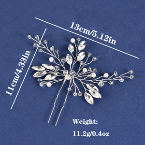 Handmade bridal hair pin with pearls and rhinestones on blue textured background