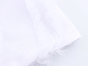 Detail shot of the white textured weave fabric and fringe trim on sleeveless dress