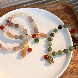 Close-up of Chinese style beaded bracelets with gourd charms and colorful gemstones