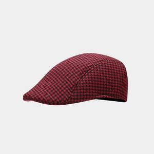 Detailed close-up of red and black houndstooth pattern wool texture on a beret cap