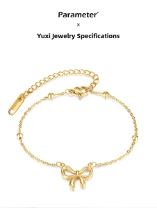 Detail of gold beaded bracelet featuring a bow pendant and adjustable extension chain