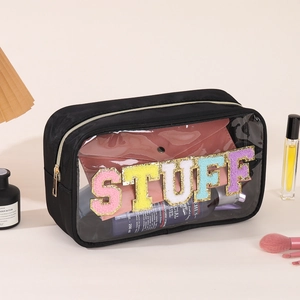Detail of clear PVC makeup bag featuring colorful chenille STUFF patches and gold zipper