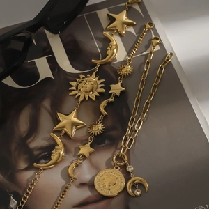 Detailed view of 18k gold plated stainless steel star moon and coin pendant necklaces
