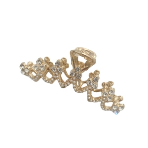 Elegant gold metal hair claw clip with pearls and rhinestones on a white background