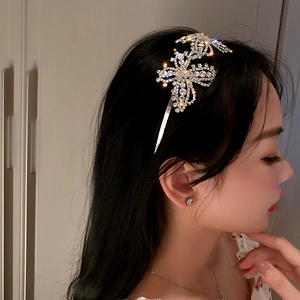 Detail shot of a silver butterfly headband with shimmering rhinestones on a female model