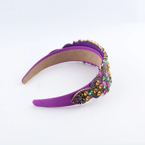 Detailed close-up of a Baroque purple headband with colorful crystals and gold metal settings