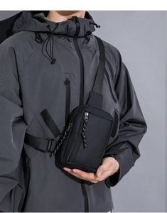 Detail of waterproof black tactical chest bag with textured fabric and vertical zipper