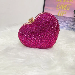 Detailed view of rose red rhinestone heart evening bag with gold clasp and metal frame