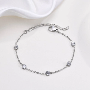 Elegant stainless steel chain bracelet with five bezel-set zircon stones on white silk background
