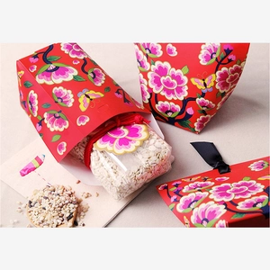 Detailed view of red floral gift box with butterfly pattern and cereal bags inside