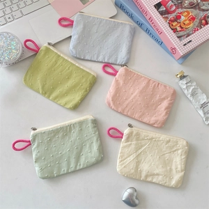 Flat lay of colorful textured fabric pouches for lipstick and small item storage