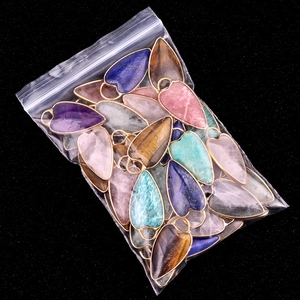 Mixed natural stone heart and leaf pendants with gold plated edges in a clear package
