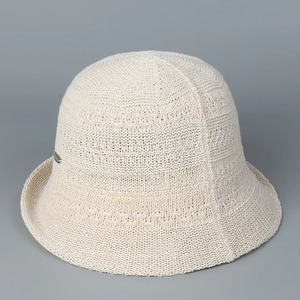 Detail of off-white knitted bucket hat showing textured weave and metal accent