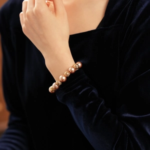 Close-up of elegant gold hollow beads and pearls bracelet on a model wrist