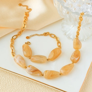 Detail of gold chain necklace with irregular amber stones and matching bracelet set