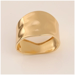Close-up of golden irregular metal cuff bracelet with a smooth and glossy finish