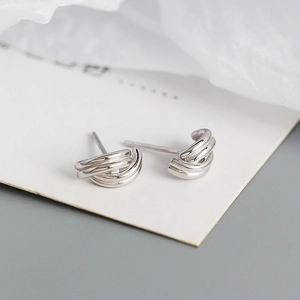Macro shot of silver geometric earrings with a triple-layered curved line design