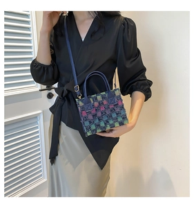 Detail of tweed crossbody bag with multi-color checkered pattern and gold hardware