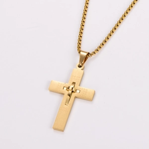 Macro shot of gold cross pendant with brushed and polished metal textures on box chain