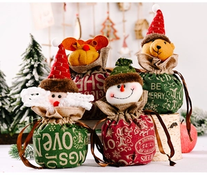 Detail of four linen Christmas drawstring bags with Santa, Reindeer, Bear and Snowman dolls