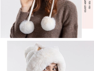 Close-up detail of white plush cat ear winter hat with soft pom-pom ties and warm faux fur