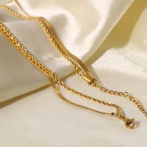 Double-layered gold stainless steel necklace with snake and twisted chains on silk