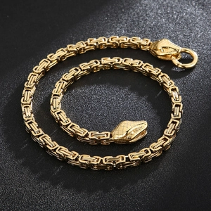 Vue macro d'une chaîne byzantine dorée avec fermoir en tête de serpent sur fond noir