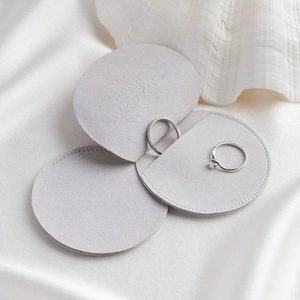 Microfiber envelope jewelry pouch in light gray with two silver rings inside