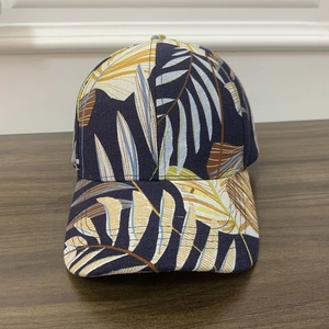 Fashionable navy blue baseball cap with tropical palm leaf print on a wood background