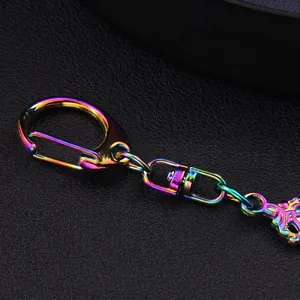 Rainbow metal cross keychain with iridescent plating and spring hook on black background