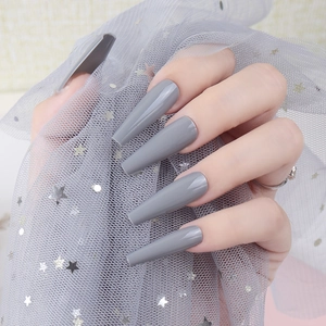Glossy dark grey long coffin press-on nails shown on hands with glitter background