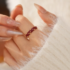 Macro detail of gold plated vintage ring with red enamel and diamond texture