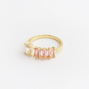 Detailed macro of gold adjustable ring featuring rectangular pink and white cubic zirconia
