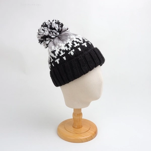 Detailed knit texture and pom-pom detail on a geometric pattern winter beanie hat