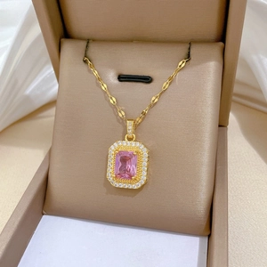 Gros plan détaillé d'un collier en or avec une pierre rose carrée et un halo de diamants