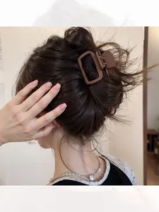 Dark brown matte rectangular hair claw clip shown on a half-up bun hairstyle