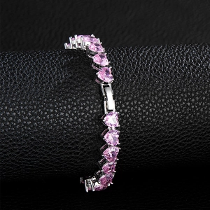 Close-up of pink heart-shaped zircon stones set in a silver tennis chain necklace