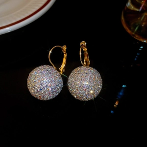 Macro shot of sparkling gold spherical earrings with colorful pave-set rhinestones