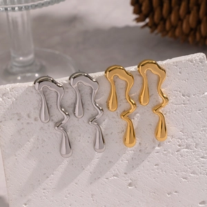 Gros plan de boucles d'oreilles géométriques irrégulières en métal doré et argenté