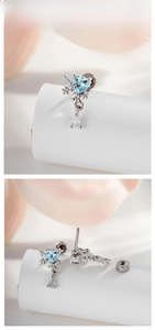 Detail of heart-shaped blue zircon stud earrings with a dangling teardrop crystal